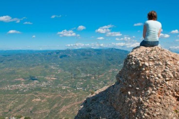 11710302-young-girl-sitting-on-an-edge-of-a-cliff